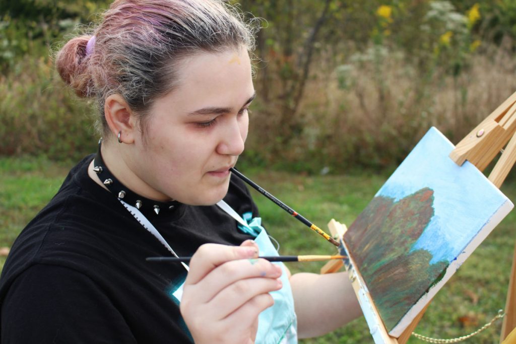 JMHS student Hailey Rogers paints the scenery at the Grand Vue Park overlook. 