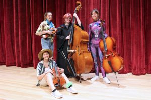 Pictured are students, in costume, from the John Marshall High School Strings program who will perform with their classmates and middle school students. Seated: A.C. Cumberledge. Standing from left: Cora Spielvogel, Grey Woods and Annadra Dudley.