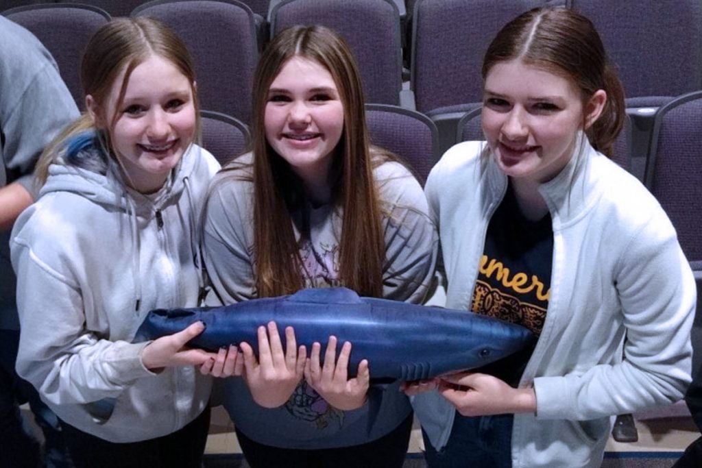 Pictured from left: CHS 8th grade students Alyssa Beucke, Natalie Burger and Scarlett Nichols look at display items from the USS Indianapolis.