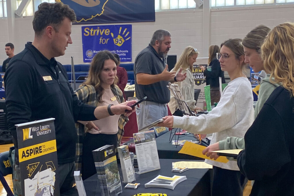 Students talk to a university representative. 